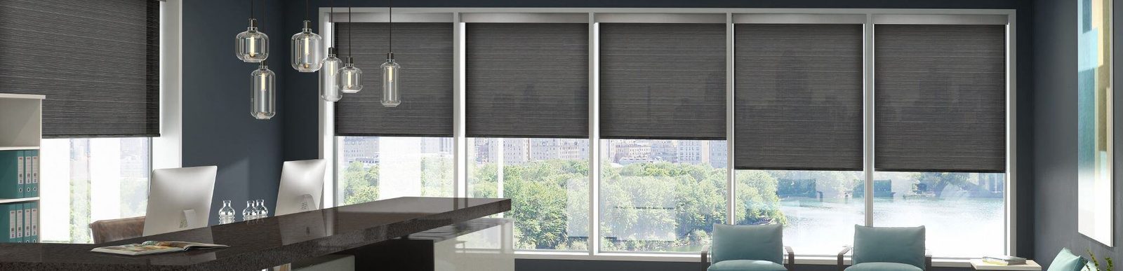 Office with dark roller shades on tall windows